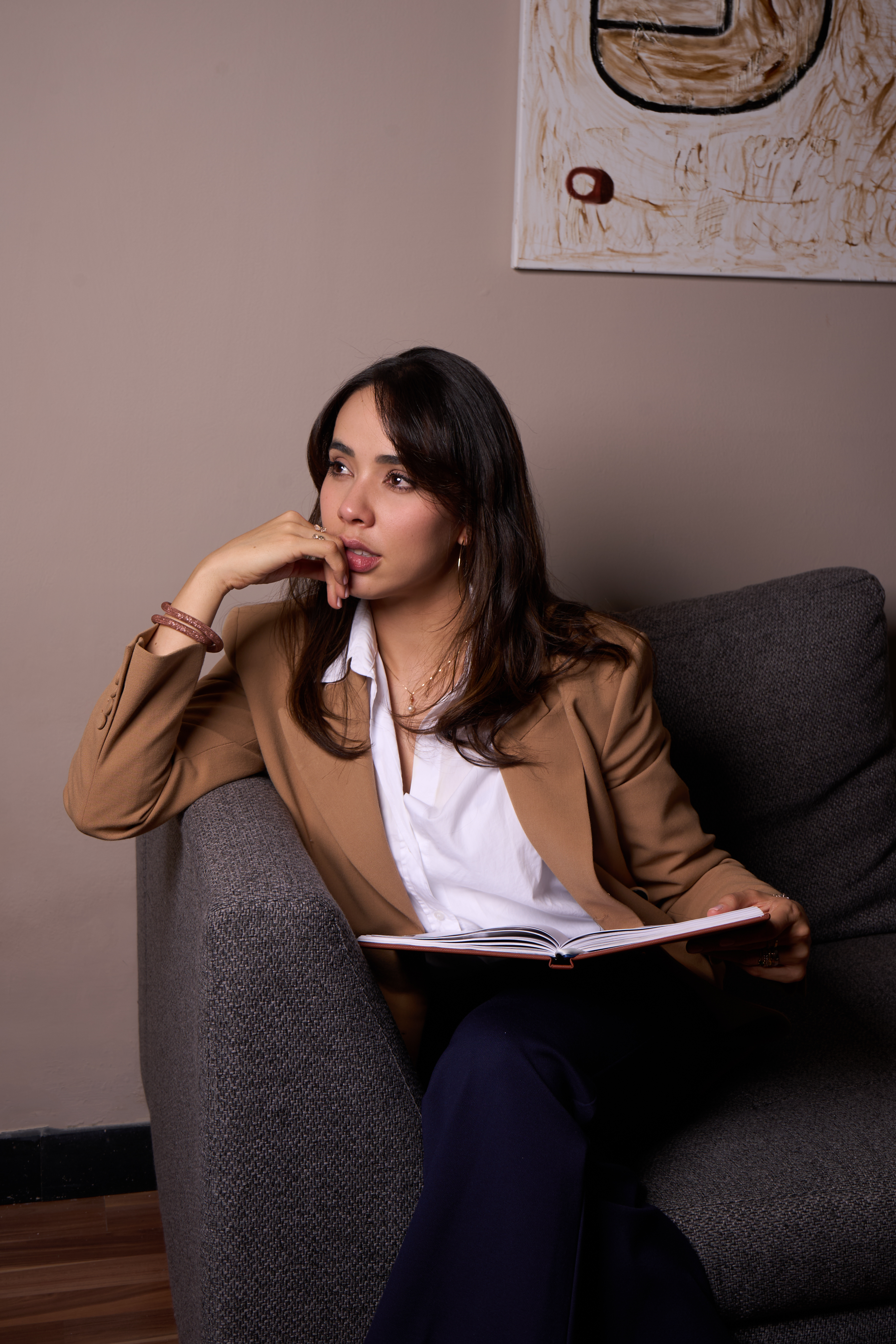 Amanda Aires sentada en un sillón con un cuaderno